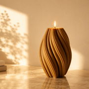 Wooden candle holder with a lit candle on a wooden surface with books and a vase in the background.