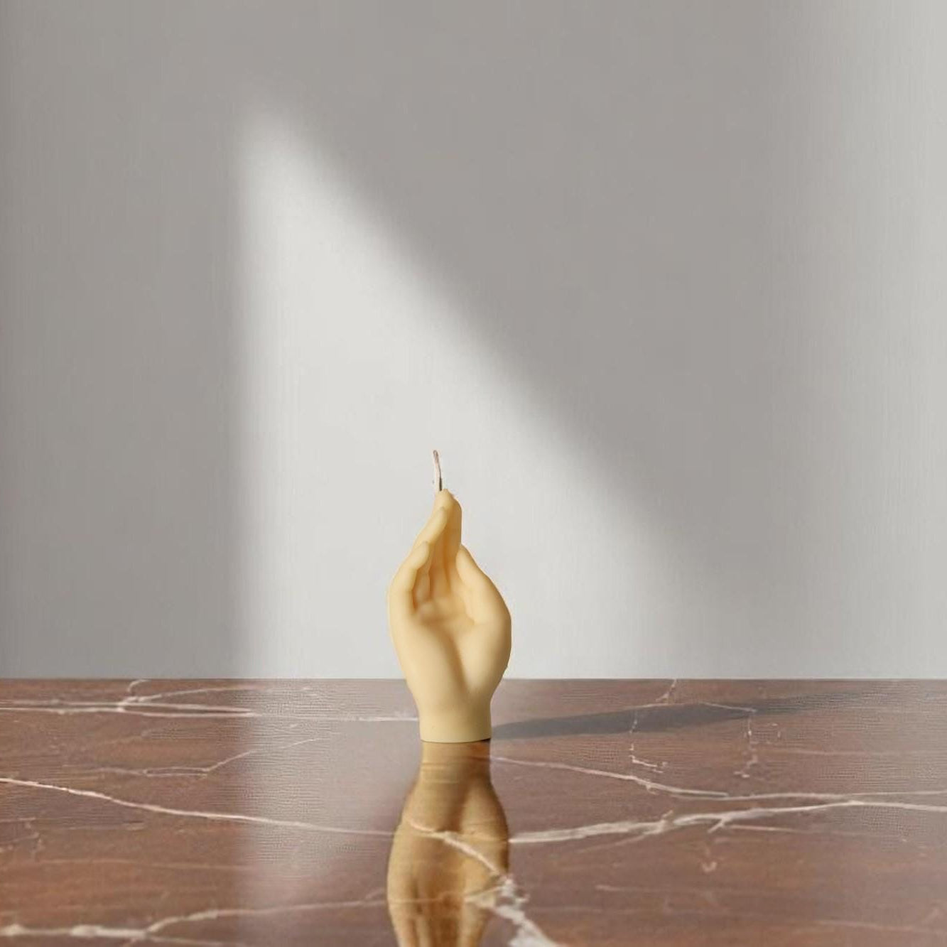 Candle on a marble surface with a gray wall background